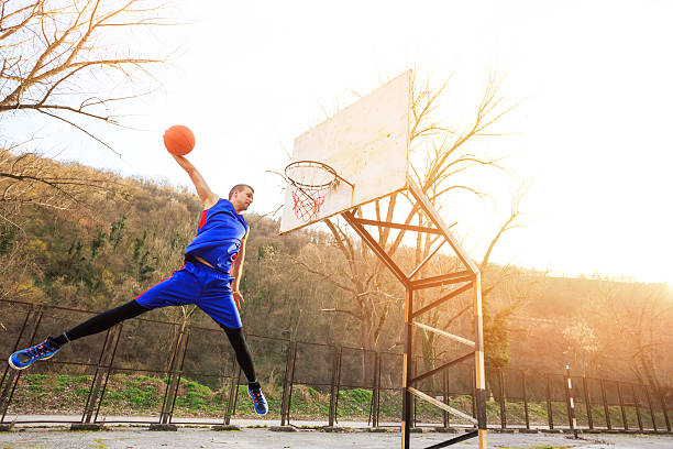 istock Street basketball player making slam dunk-full-length 514462520