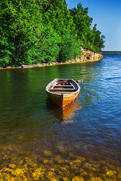 деревянная лодка на берегу реки - rowboat river lake nautical vessel стоковые фото и изображения