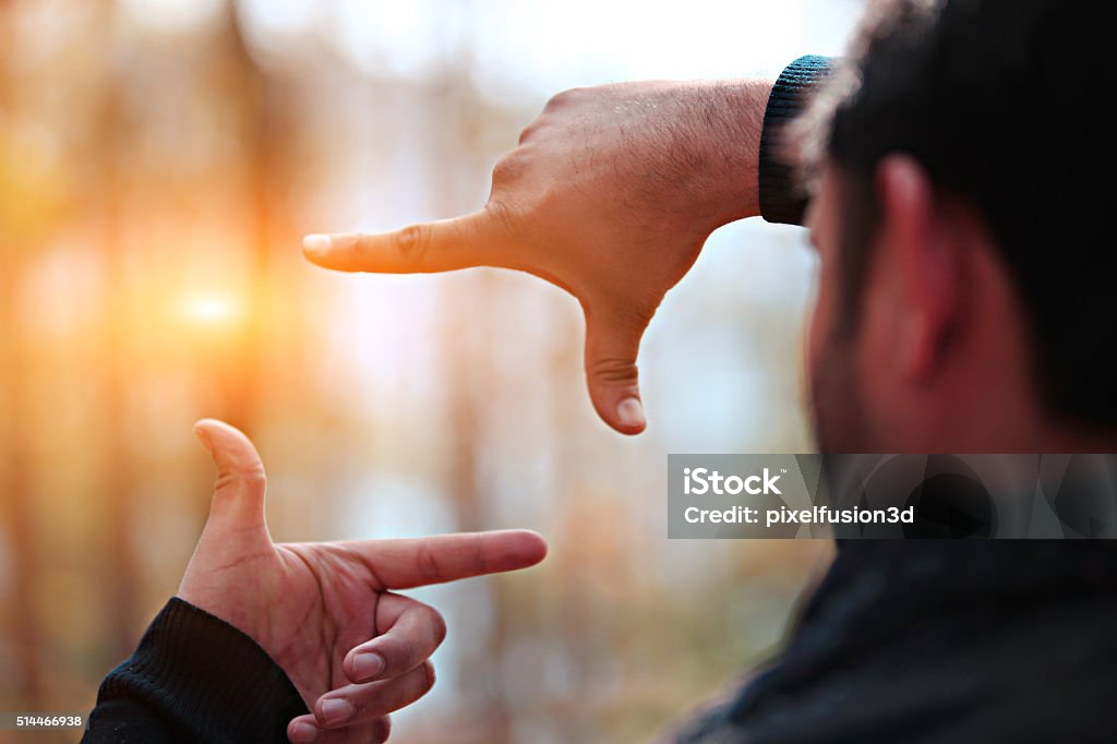 Beauty In Composition Frame Man hands framing distant sun rays.  Focus - Concept Stock Photo