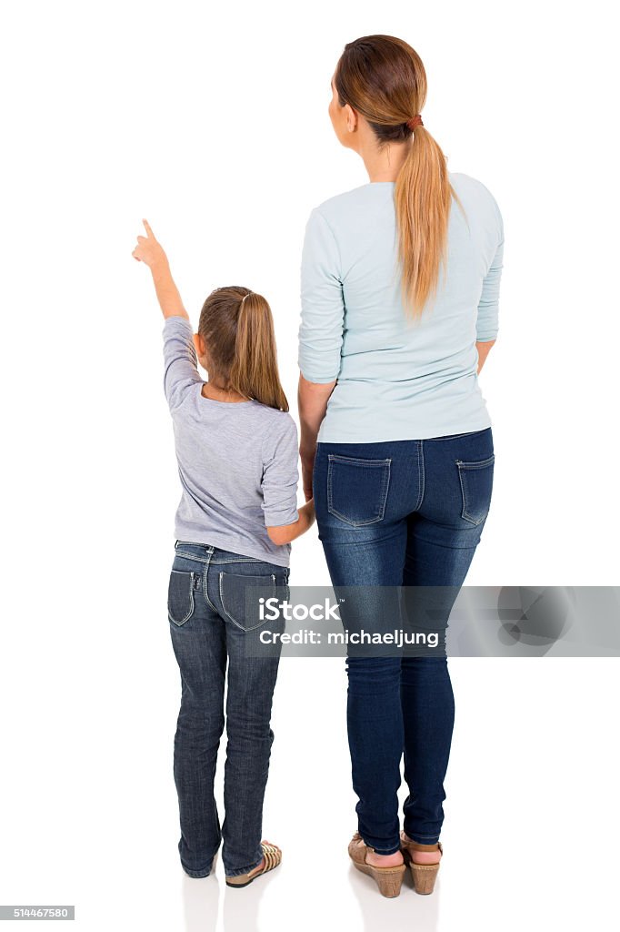 young mother and daughter pointing rear view of young mother and daughter pointing at empty space Rear View Stock Photo