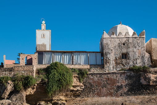 Small mosque in the village on the coast of Atlantic Ocean in Morocco, Moulay Bouzerktoun. Bright blue sky.