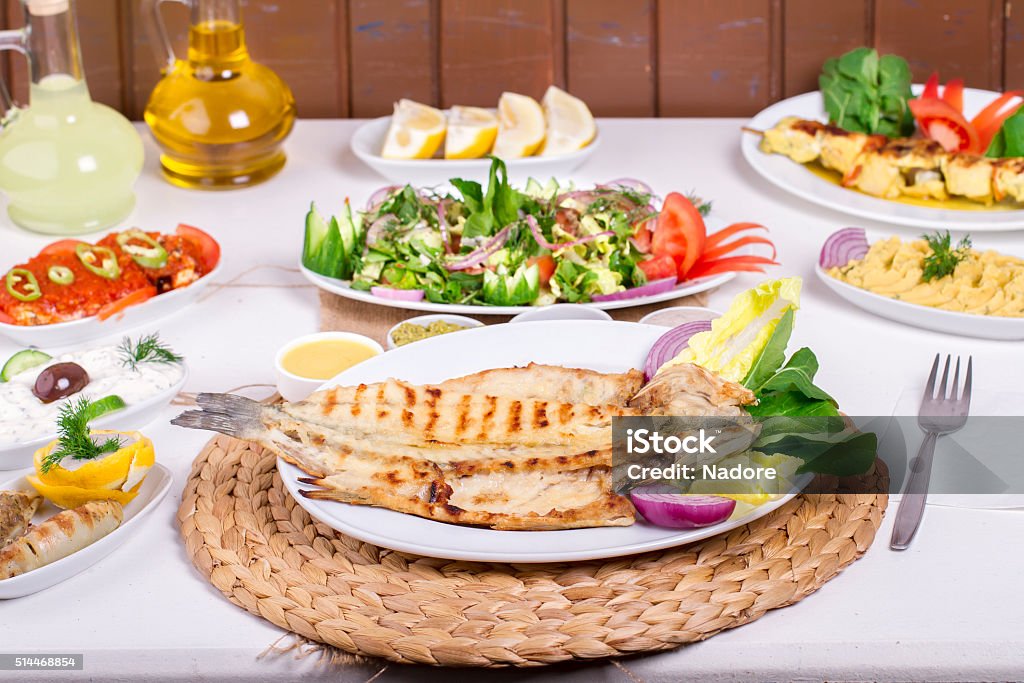 Turkish and Greek Table with Special Alcohol Drink Raki, Ouzo Turkish and Greek Traditional Dinning Table with Special Alcohol Drink Raki, Ouzo Striped Bass Stock Photo