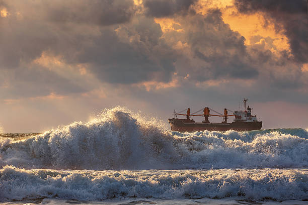 puesta del sol en el mar con la navegación barco de carga - sailing ship industrial ship horizon shipping fotografías e imágenes de stock