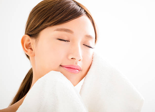 istock young woman cleaning her face with  towel 514471128