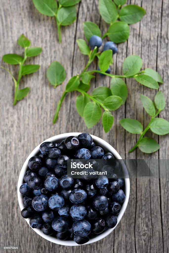 Ripe blueberries, top view Ripe blueberries in bowl on wooden background, top view Berry Fruit Stock Photo
