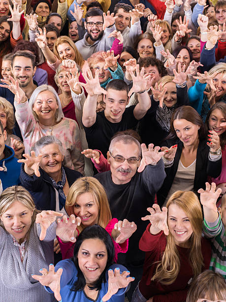 istock Above view of crowd with raised arms looking at camera. 514473616