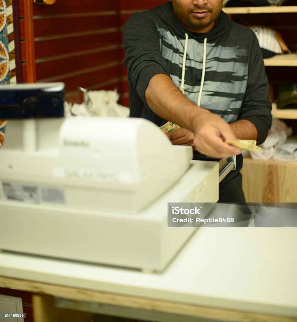 Business owner Counting money and returning change at a cash register used at small businesses Buying Stock Photo