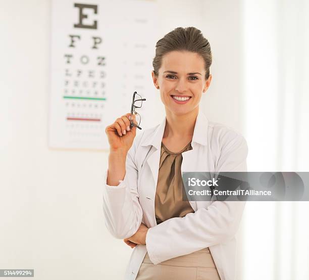 Doctor Woman With Eyeglasses In Front Of Snellen Cha Stock Photo - Download Image Now