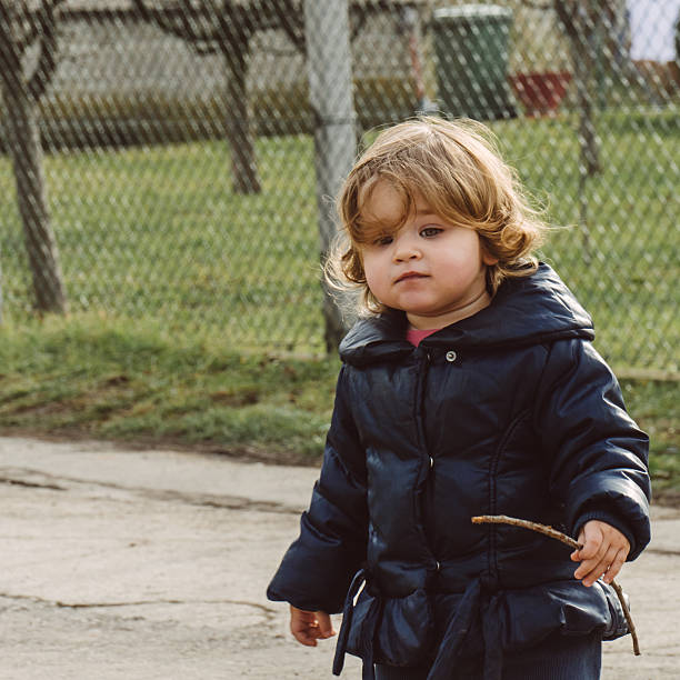 istock Baby girl walking with branch in her hand 514501062