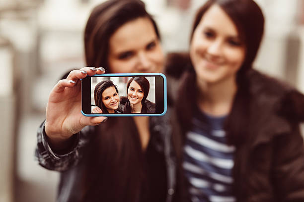 istock Happy girls taking selfie together 514505850