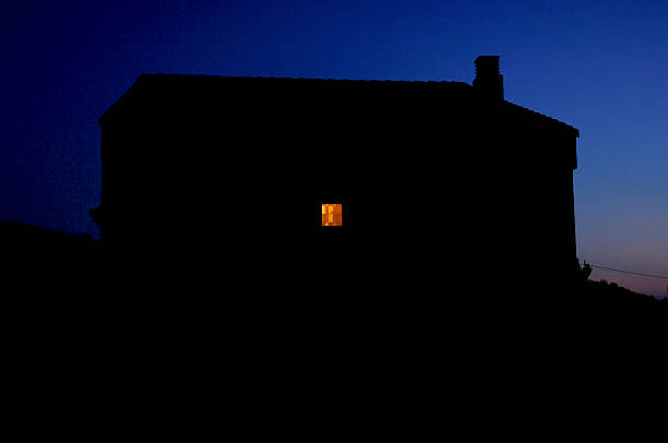 istock Small lit window in an isolated house at nigh 514506354