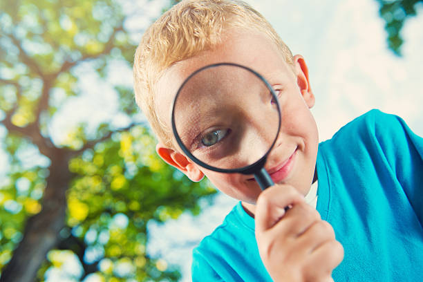 istock Cute boy in a park with a magnifying glass 514506638
