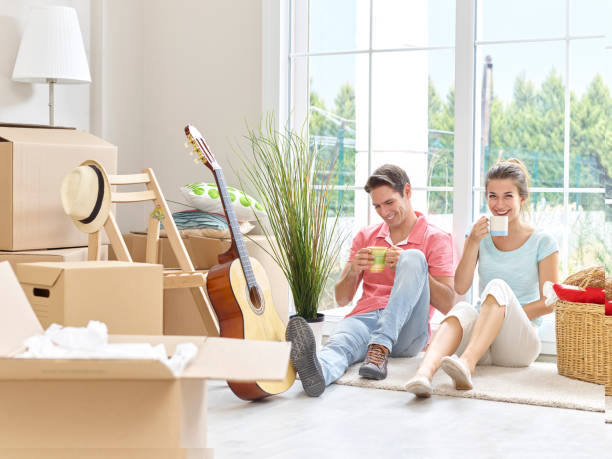 istock Couple surrounded by moving boxes relaxing with coffee 514508160