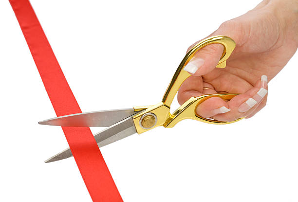 istock single female hand with Scissors and red tape 514508448