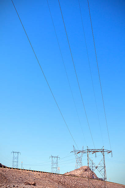 istock High voltage towers standing by a road on rocky desert. 514508616