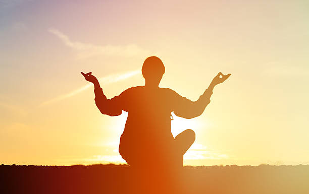istock man doing yoga at sunset sky 514511392