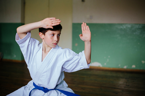 Strong young woman kicking and showing power during her taekwondo class with a karate trainer