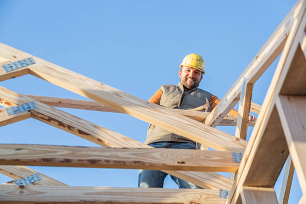 istock Construction worker with hammer on roof of house frame 514514008