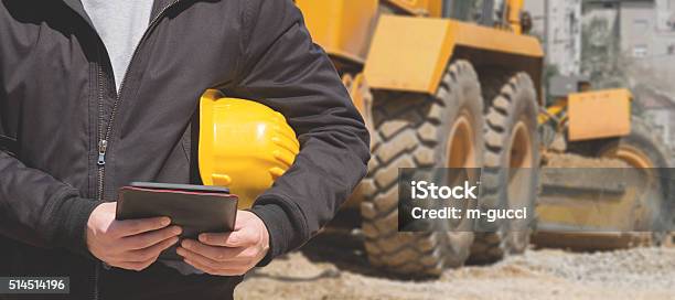 Real And Ordinary Construction Worker On His Job Stock Photo - Download Image Now - Backhoe, Digital Tablet, Construction Site