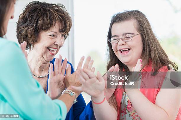 Down Syndrome Girl With Family Playing Games Stock Photo - Download Image Now - Disability, Down Syndrome, Adult