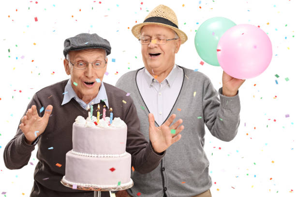 istock Two excited seniors blowing candles on a cake 514514488
