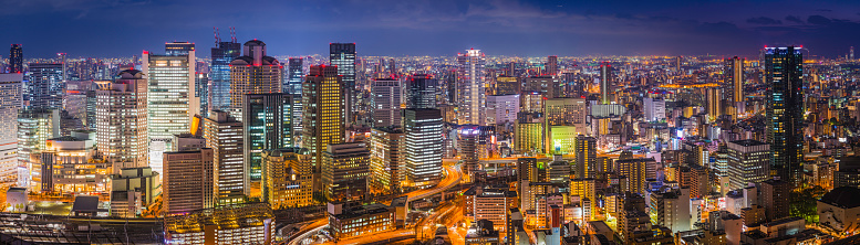 The glittering lights, neon night, soaring skyscrapers and zooming highways of the futuristic crowded cityscape of central Osaka, Japan. ProPhoto RGB profile for maximum color fidelity and gamut.