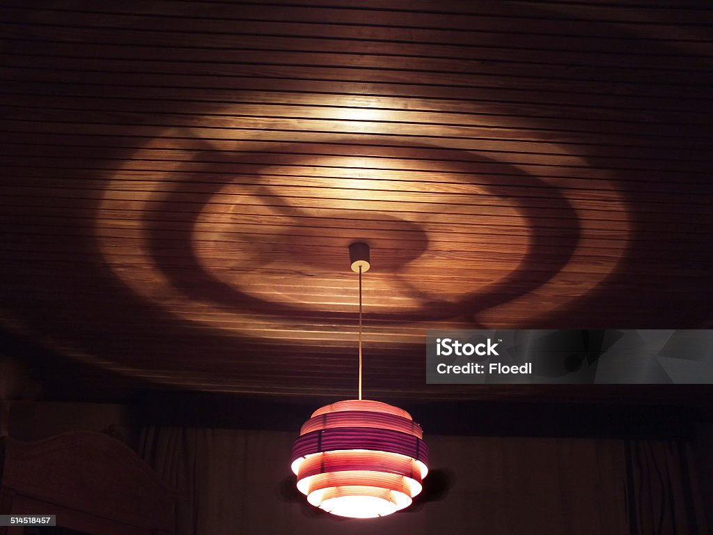 Lamp with shadow play Wood chip lamp casts shadows and light on the ceiling Electric Lamp Stock Photo