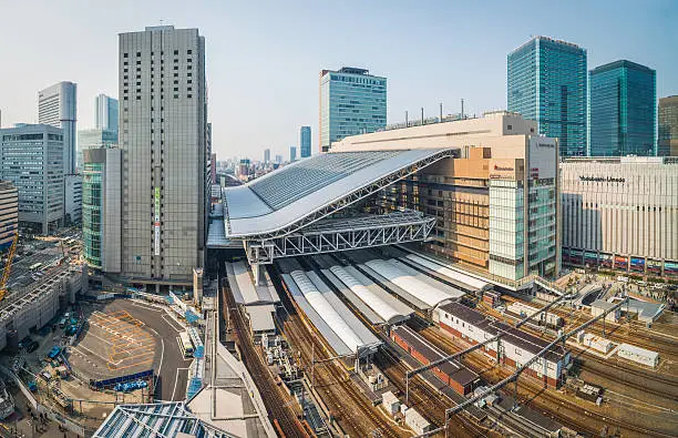 High angle view over the tracks and platforms of Osaka Station surrounded by the skyscrapers of Umeda in the busy heart of Japan's second city. ProPhoto RGB profile for maximum color fidelity and gamut.