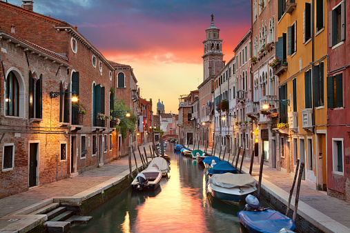 Image of one of many narrow canals in Venice during beautiful sunset.