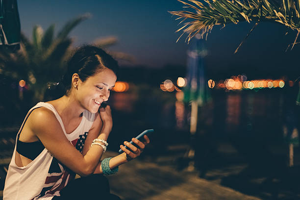 istock Girl at the beach by night using smartphone 514521084