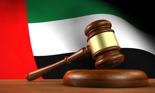 United Arab Emirates law, legal system and justice concept with a 3d render of a gavel and the UAE flag on background.