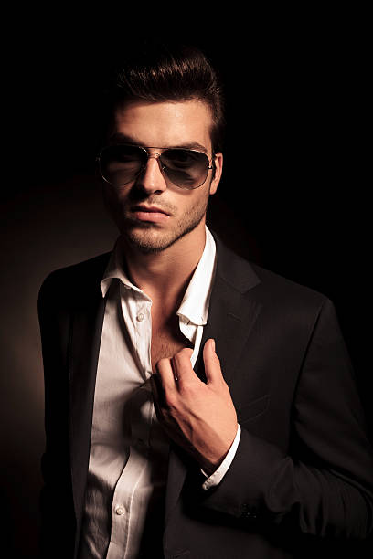 istock man in suit and sunglasses holding his suit by collar 514538523