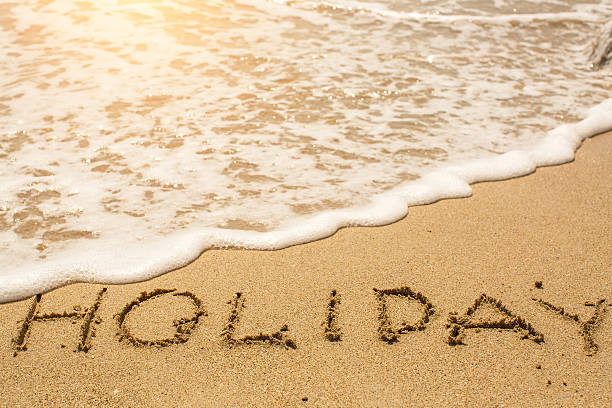 istock Holiday - word drawn on the sand beach 514553174