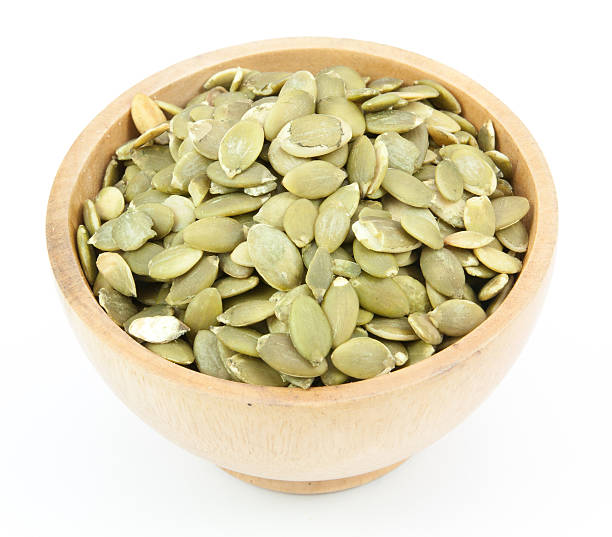 istock Pumpkin Seeds in a wood bowl 514553910