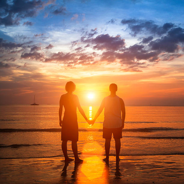 istock Happy young couple holding hands on sea beach 514557735