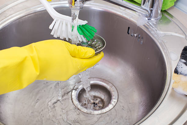istock Woman cleaning kitchen sink 514557968