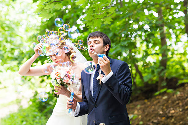 istock beautiful wedding couple blowing bubbles 514558760