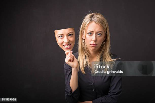 Mujer Sosteniendo La Máscara De Rostro Feliz Foto de stock y más banco de imágenes de Falso - Falso, Máscara - Disfraz, Felicidad