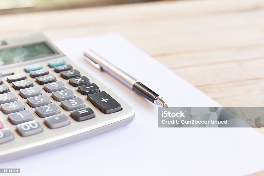 Blank white notebook with pen Blank white notebook with pen on wood desk. shallow depth of field Calculator Stock Photo