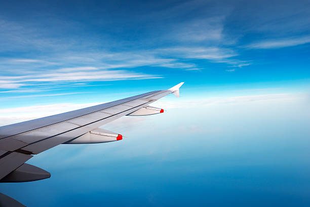 istock Wing of a Plane with Blue Sky and Clouds 514562056