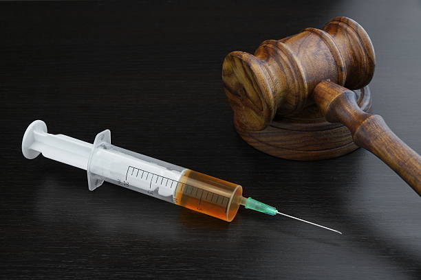 Judges Gavel And Medical Injection Syringe On Black Wooden Backg stock photo