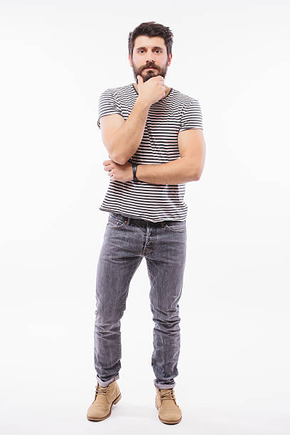 istock Handsome young man with hand on beard full height smiling 514563672