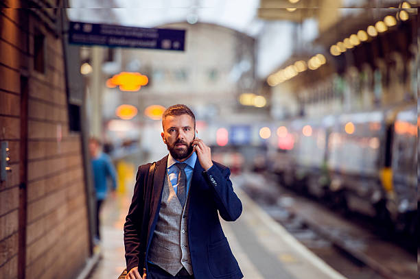 istock Businessman with smartphone, making a phone call, train platform 514564822