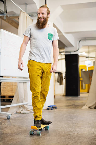 Cheerful designer skating through his office
