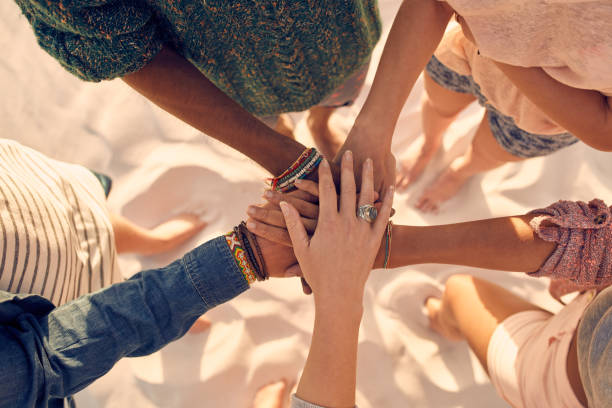 jeunes hommes et jeunes femmes montrant l'unité - holding hands human hand holding multi ethnic group photos et images de collection