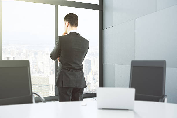 istock Businessman looks out the window in office 514566390