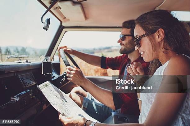 Photo libre de droit de Jeune Couple À Laide Dune Carte Un En Voiture Pour Des Itinéraires banque d'images et plus d'images libres de droit de Voiture