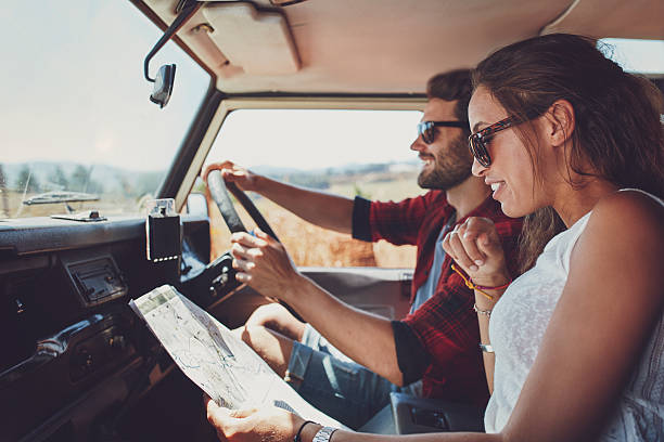 casal jovem, usando um mapa na roadtrip para as instruções - car adventure journey travel - fotografias e filmes do acervo