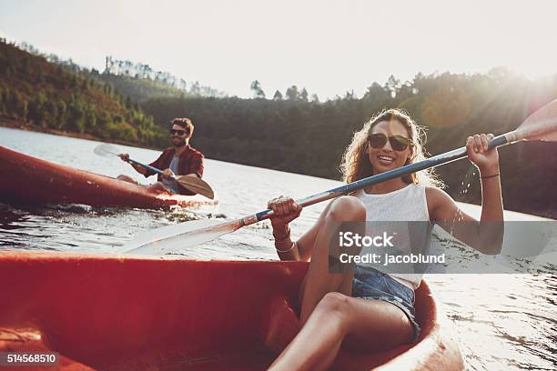 Jóvenes Piragüismo En Un Lago Foto de stock y más banco de imágenes de Kayak - Barco de remos - Kayak - Barco de remos, Kayak - Piragüismo y canotaje, Verano