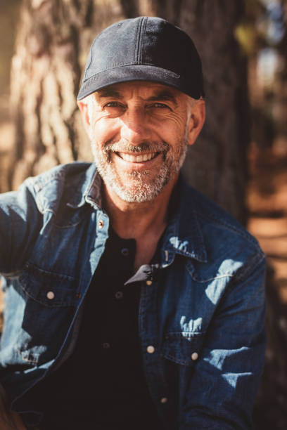 istock Senior man sitting by a tree on summer day 514568978